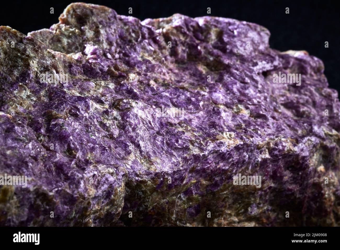 A closeup of a rare mineral row uncut purple crystal Stock Photo