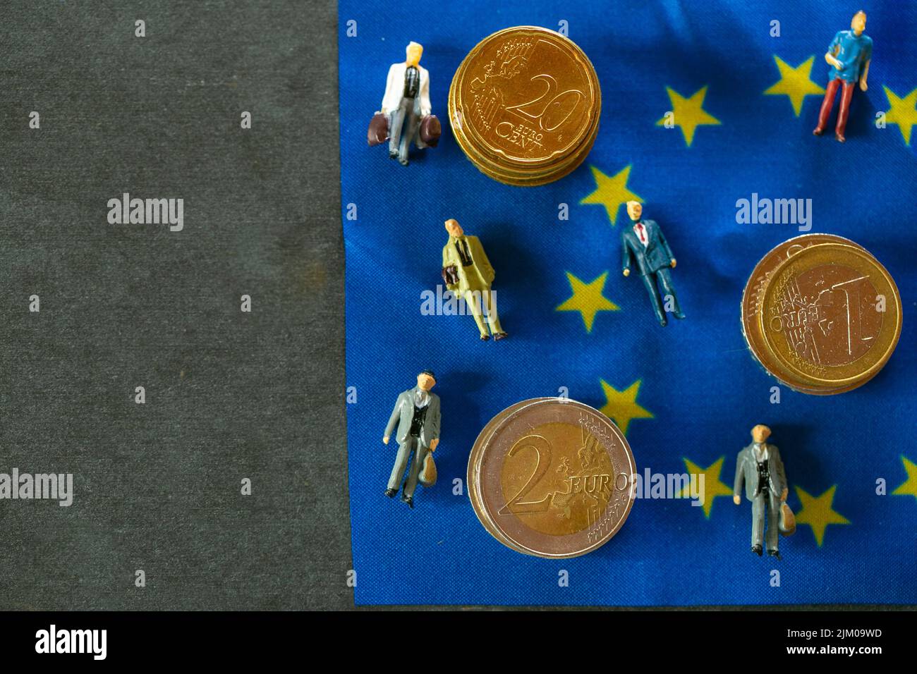 .Tax and price increases in the European Union. Taxpayers of EU countries.figurines of people and euro coins on european union flag background.Tax and Stock Photo