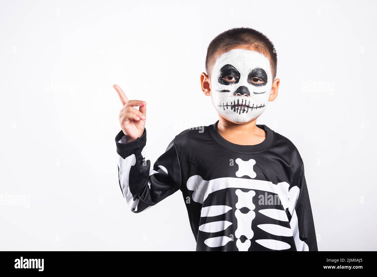 Halloween Kid. Child man horror face painting make up for ghost scary point  finger to side space, Portrait of little boy wearing skeleton costume isol  Stock Photo - Alamy