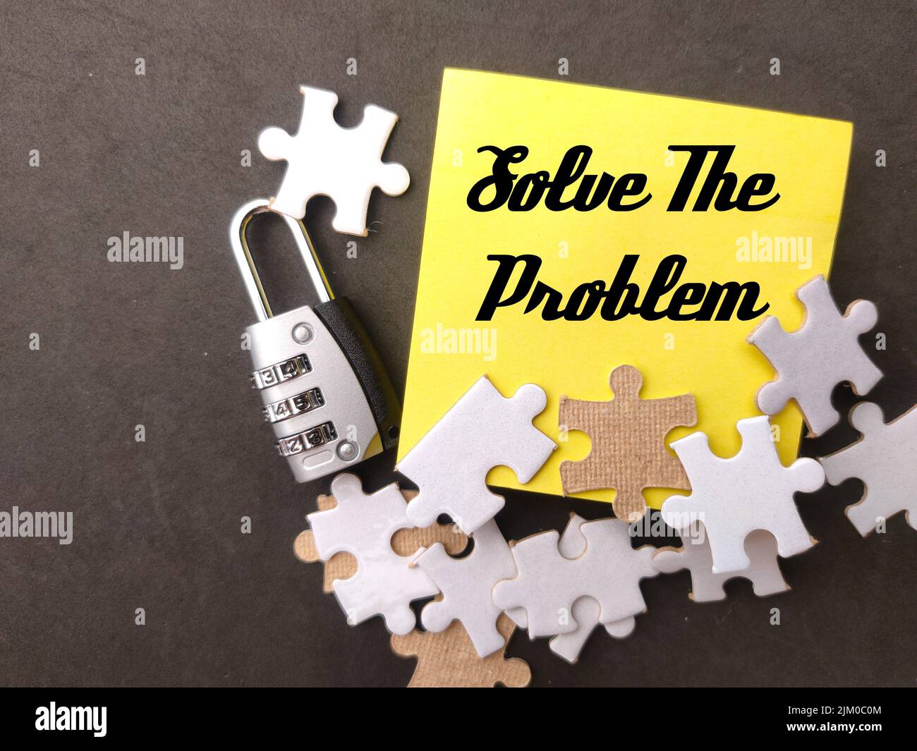 Top view padlock,white puzzle and sticky note with the word Solve The