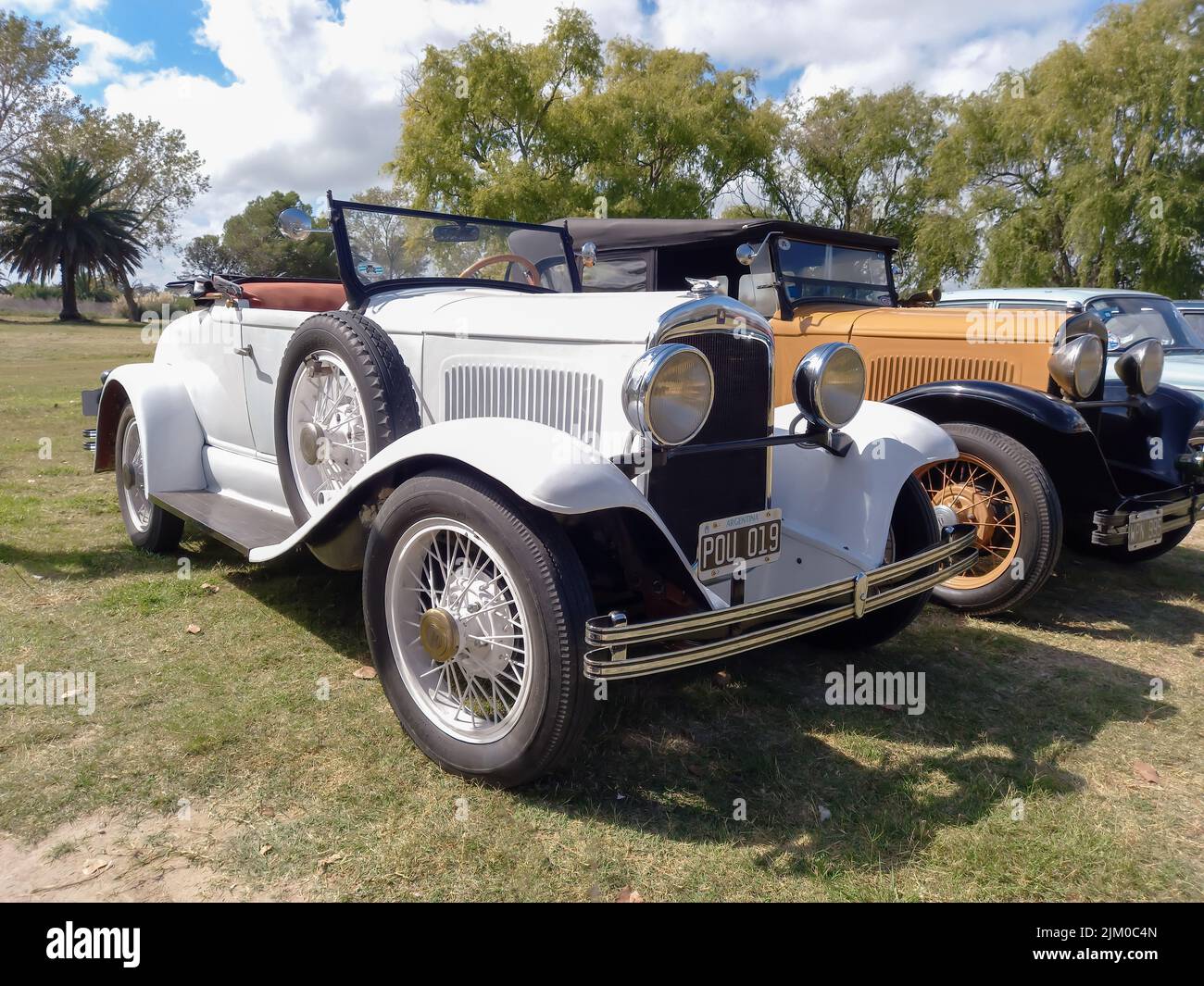 Chascomus, Argentina - Apr 9, 2022: Old white Chrysler Plymouth roadster circa 1930 parked in the countryside. Nature grass and trees background. Clas Stock Photo