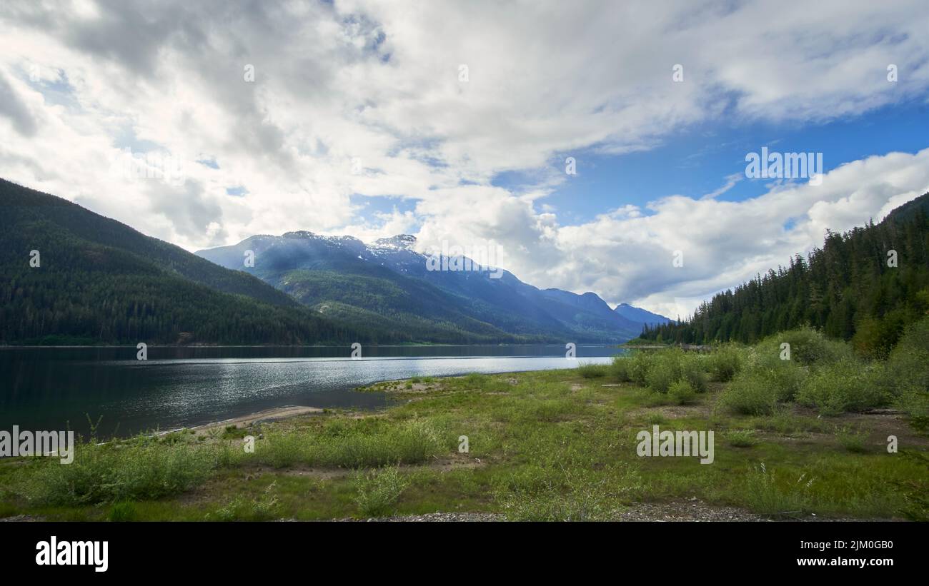 View from the foreshore of a lake and the distant mountains and dramatic sy. Stock Photo