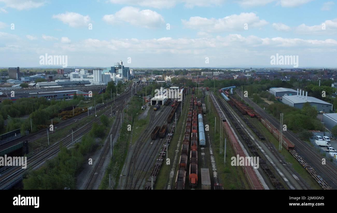 Aerial view of a railway freight yard with rolling stock and an industrial estate in the background Stock Photo