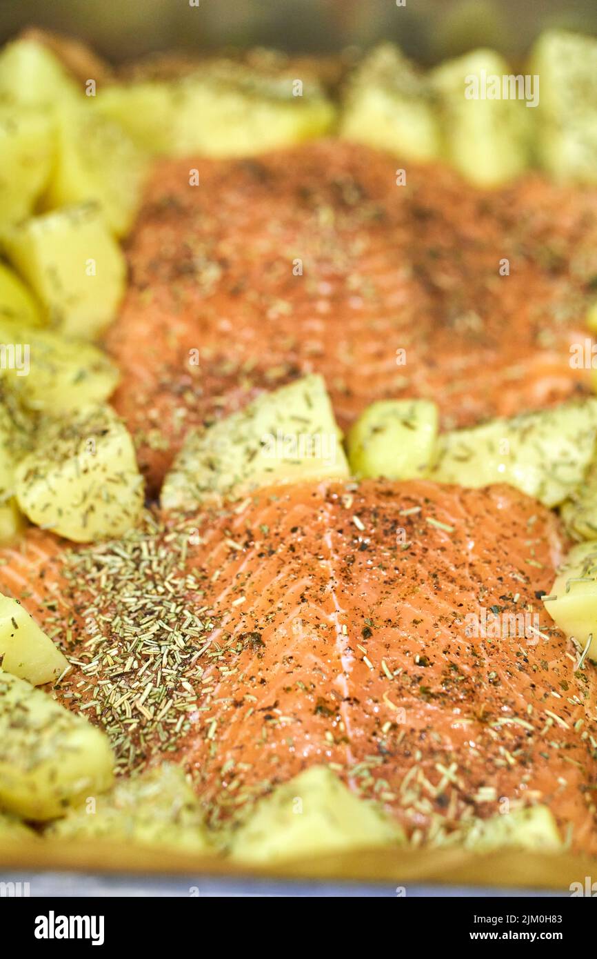 The raw salmon fish meat with potatoes in a baking tray Stock Photo - Alamy