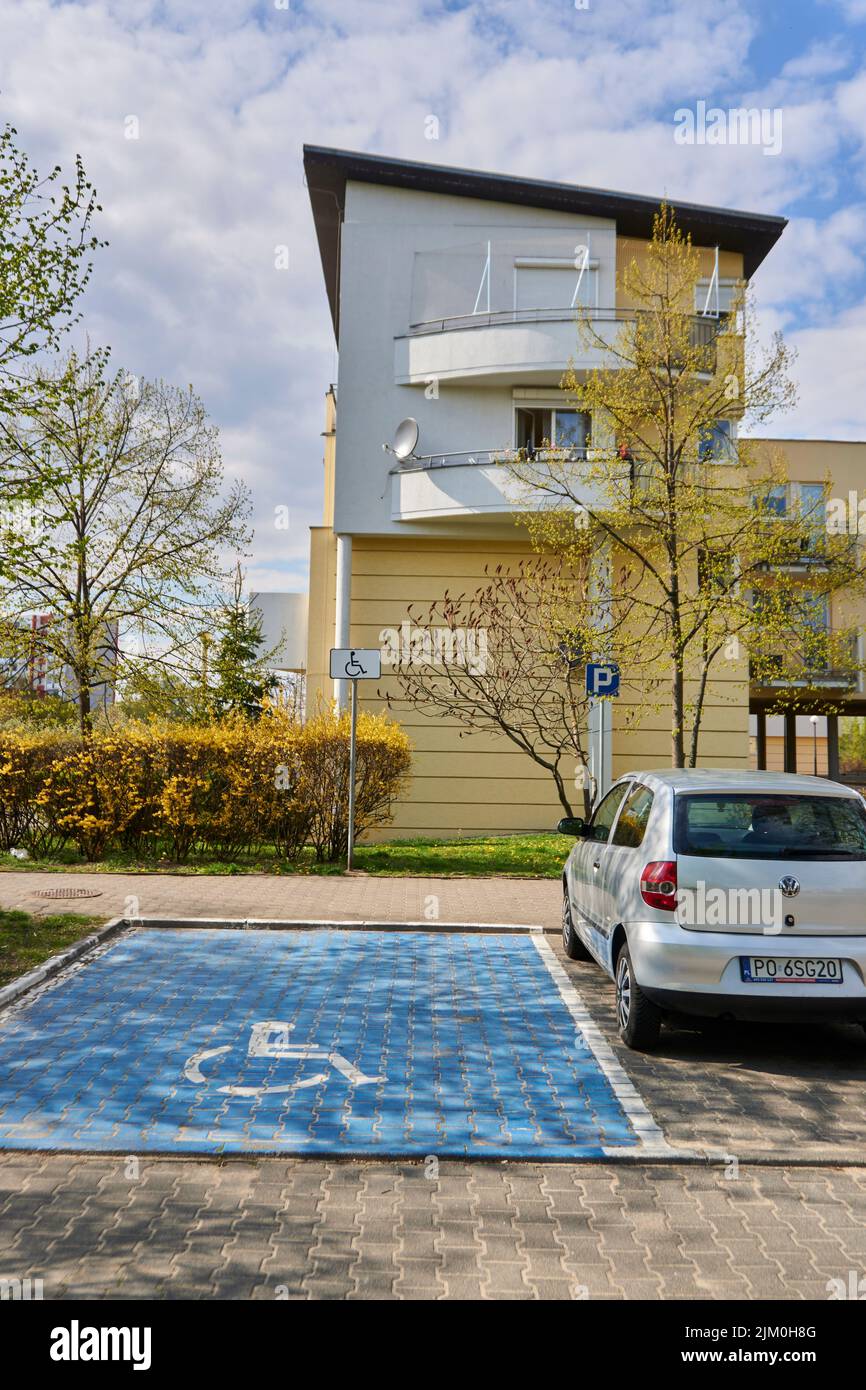 A vertical shot of a parking place for disabled drivers by an apartment