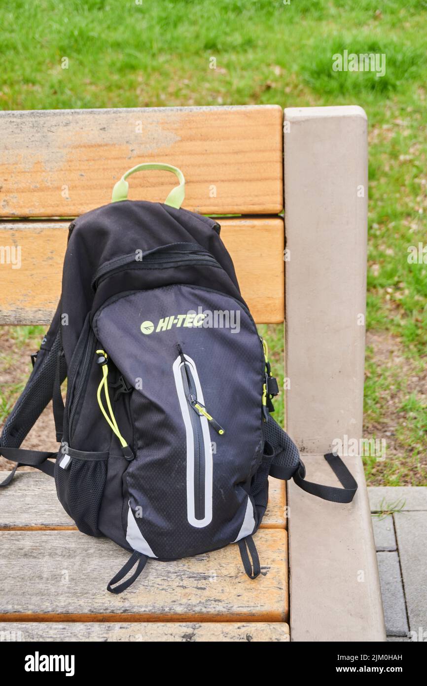 A vertical shot of a Hi Tec brand backpack on a wooden park bench. Stock Photo