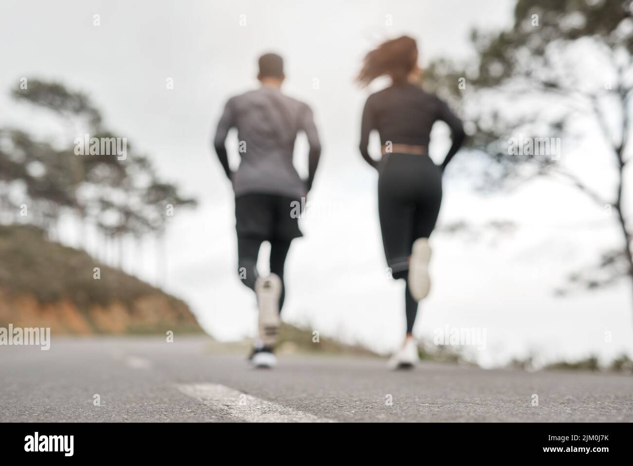 Count your breath, not your steps. Full length shot of two unrecognizable athletes bonding together during a run outdoors. Stock Photo
