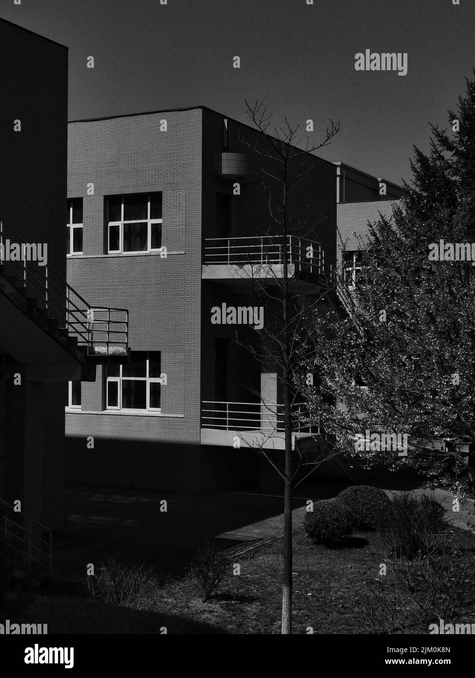 A vertical grayscale shot of a modern residential apartment building Stock Photo