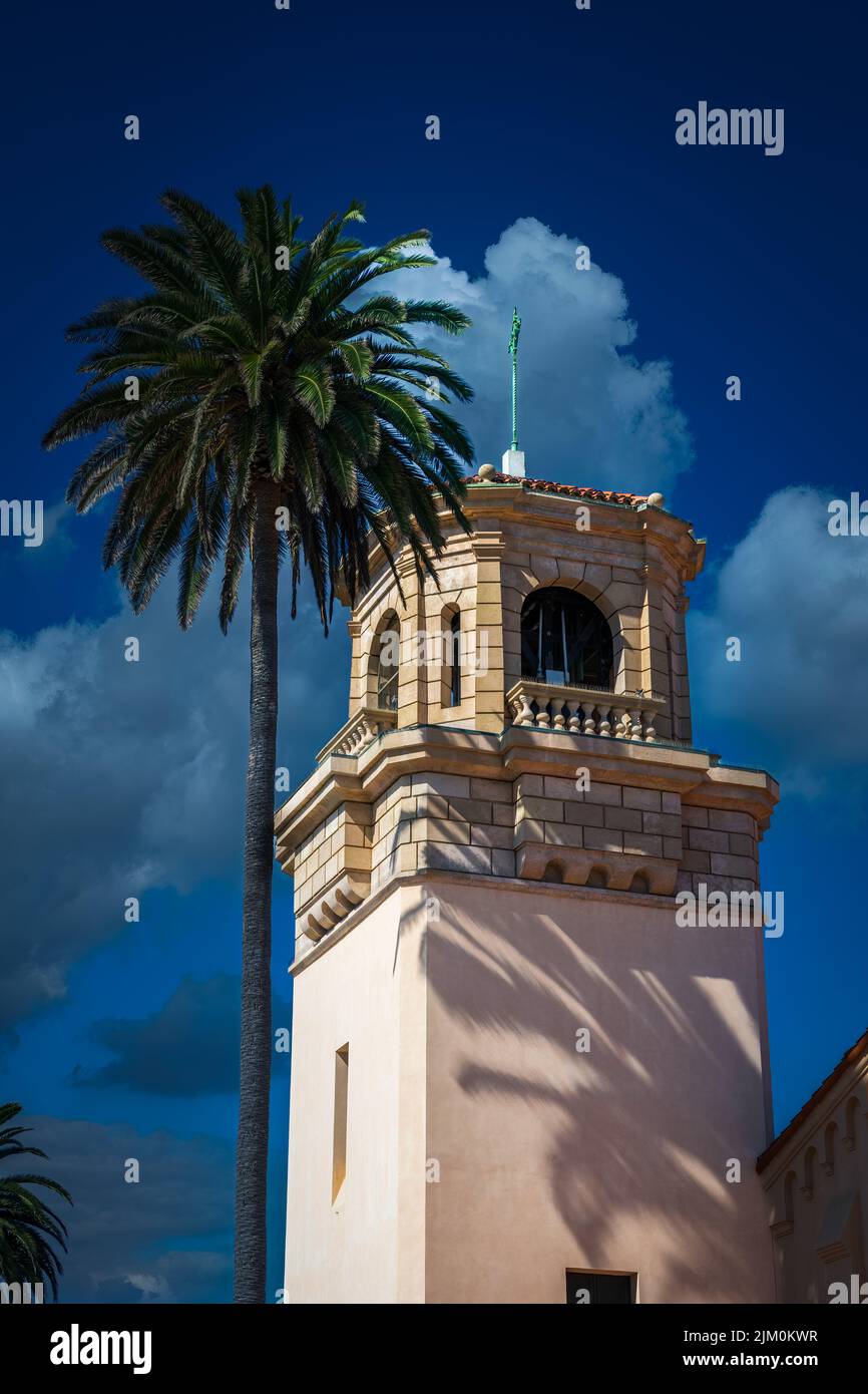 SPANISH STYLED STEEPLE WITH A PALM TREE NEXT TO IT AND A DEEP BLUE SKY WITH A FEW WHITE CLOUDS IN LA JOLLA CALIFORNIA Stock Photo