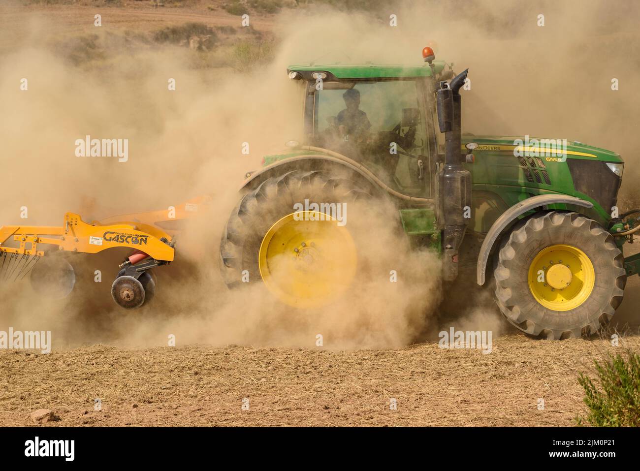 Tractor working to prevent the advance of the 2022 Pont de Vilomara wildfire with a cloud of dust due to extreme drought (Bages, Barcelona, Catalonia) Stock Photo