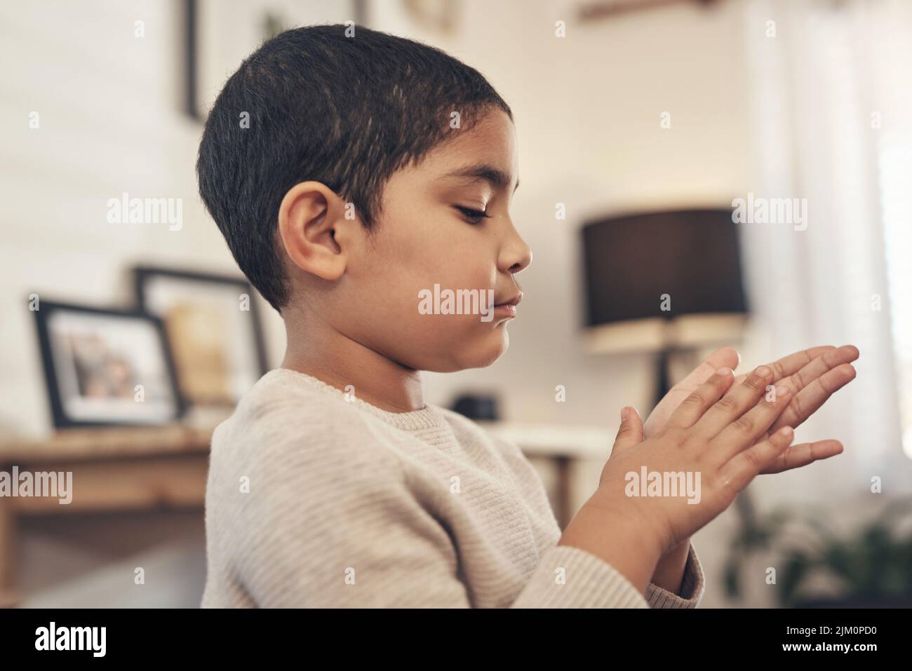 Not today, dirt. an adorable little boy disinfecting his hands at home. Stock Photo