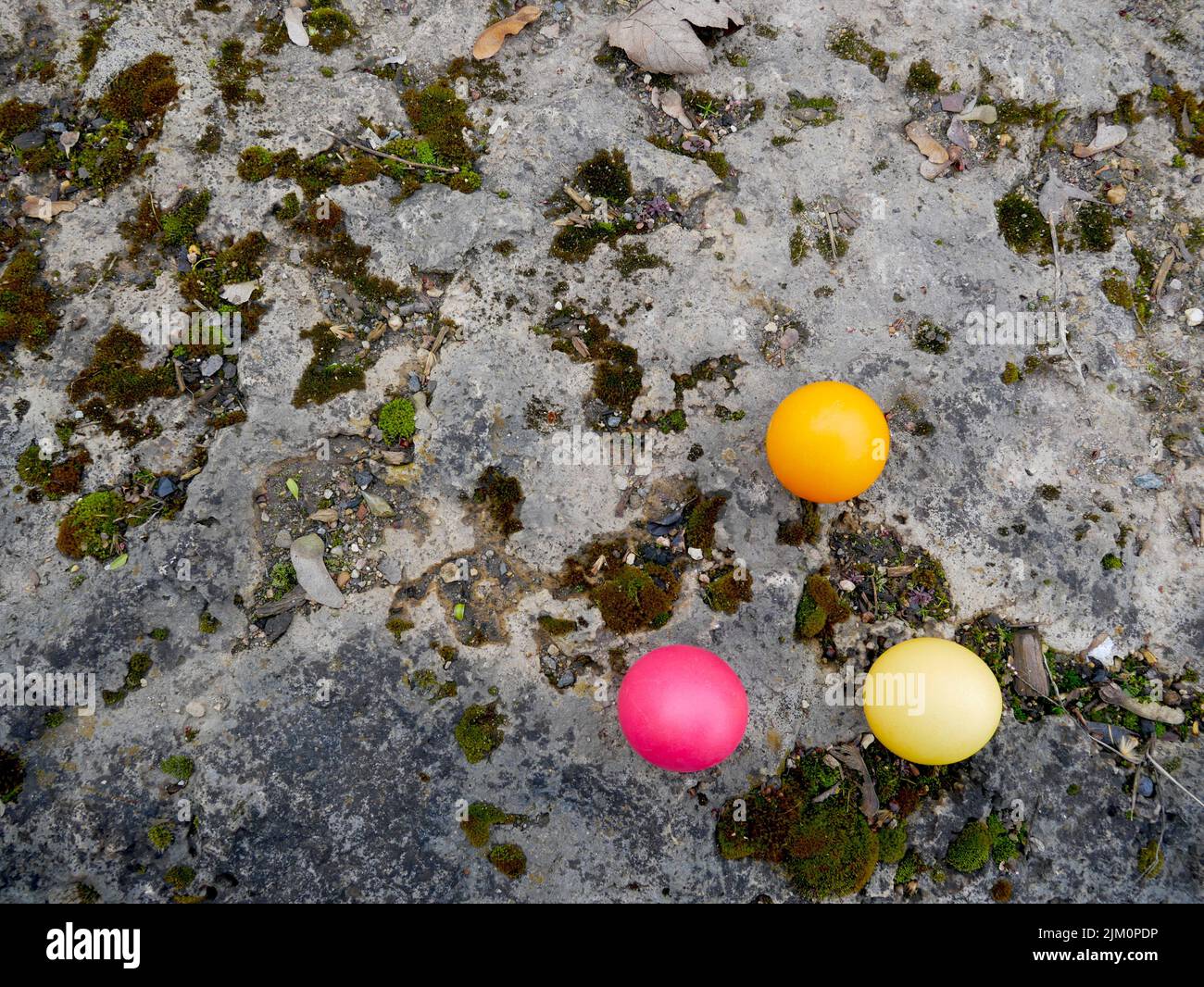 Three colored easter eggs on a stone Stock Photo