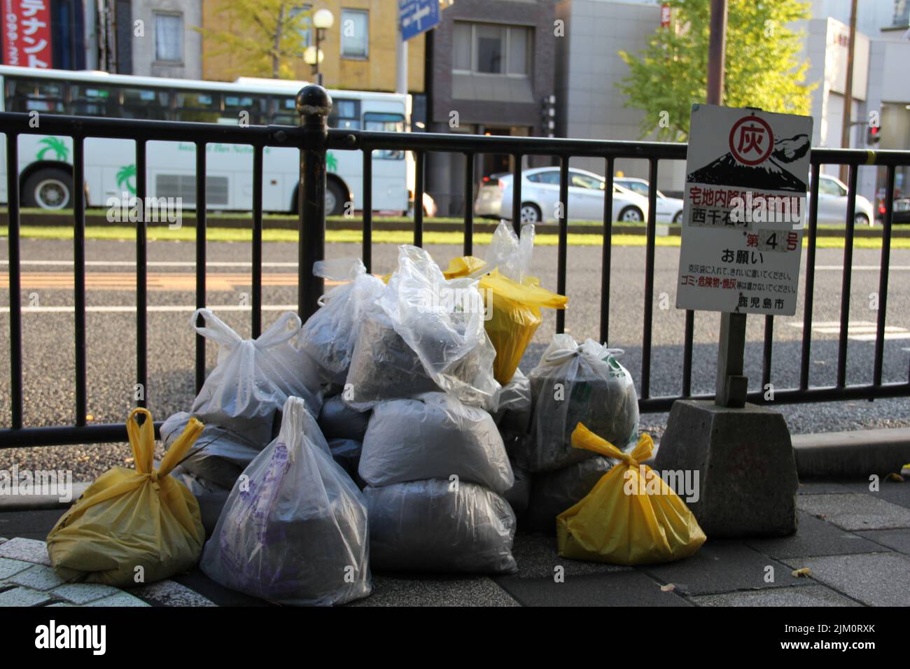 Several plastic bags of volcanic ash lie on the roadside in Kagoshima. Stock Photo