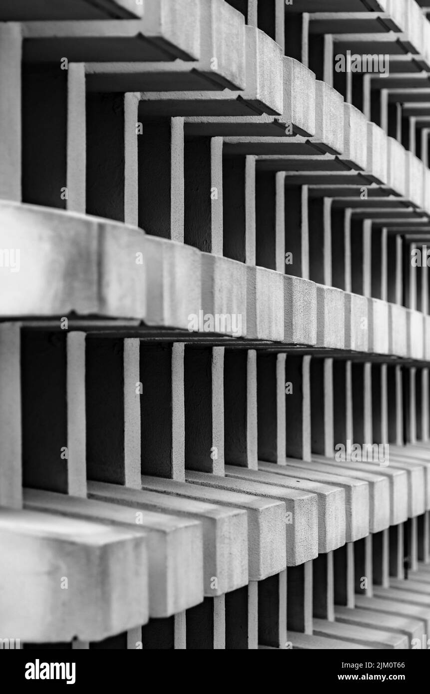 A vertical grayscale shot of the side of a stone structure with small ...