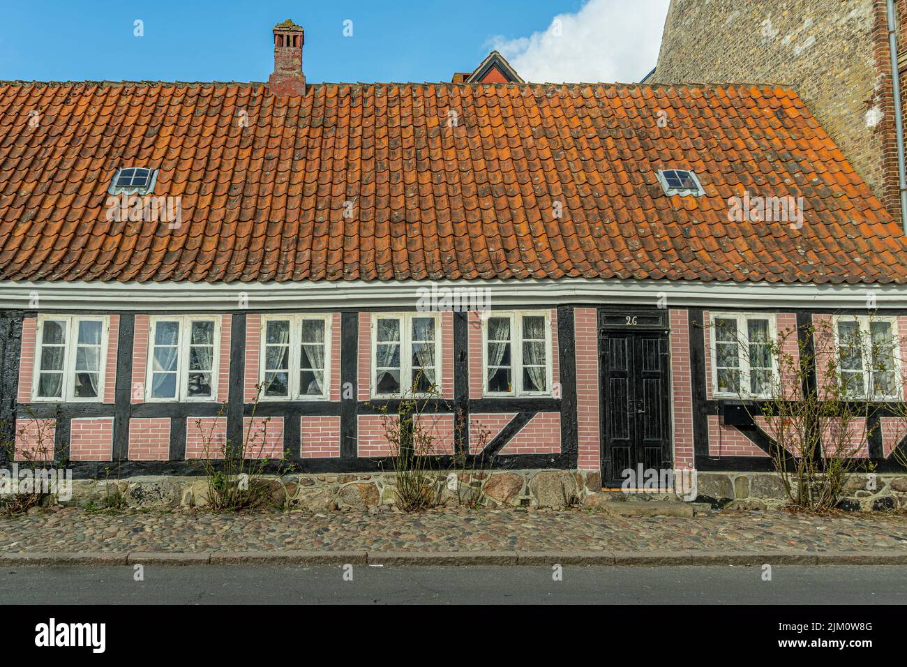 Typical Danish house with pink walls and a sloping roof in the town of