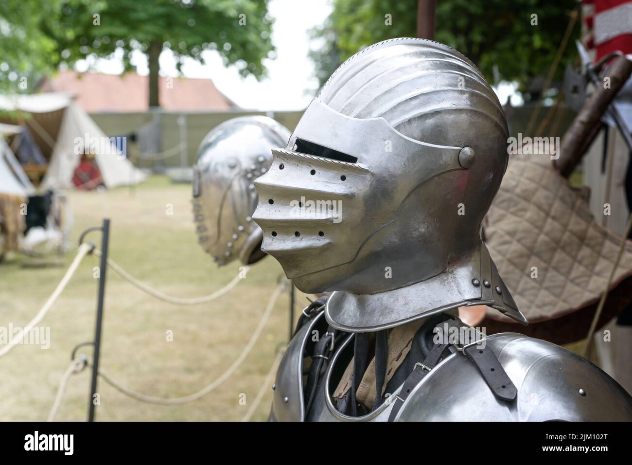 Knight helmet of metal with visor down, replica on a medieval camp with historical armor and weapons, copy space, selected focus, narrow depth of fiel Stock Photo