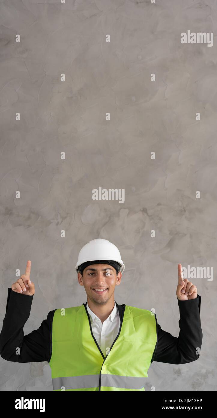 Handsome arabic man wearing safety helmet and reflective jacket smiling with an idea pointing fingers up with happy face, number two, banner Stock Photo