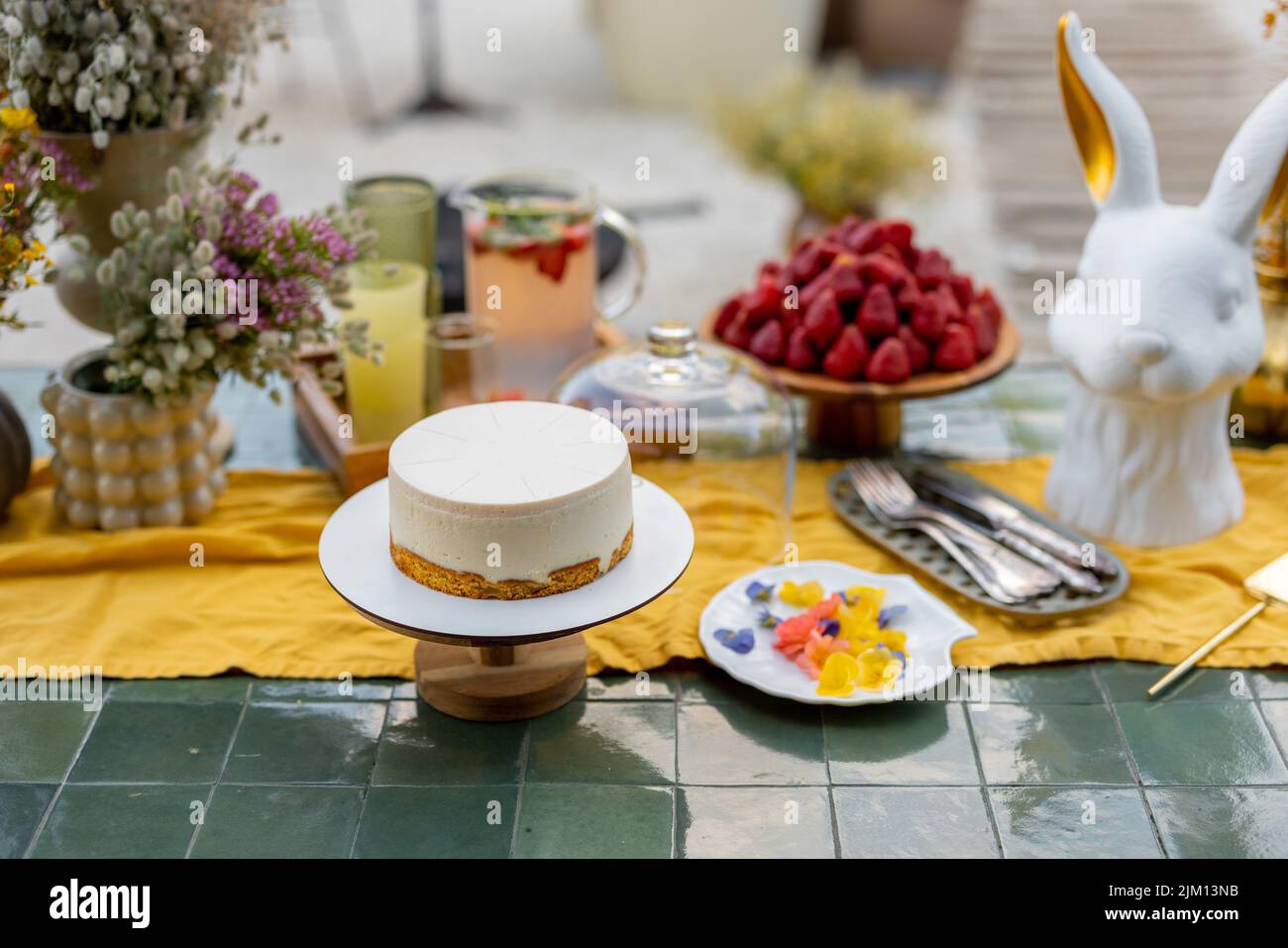 Cheesecake with edible flowers on table in garden Stock Photo Alamy
