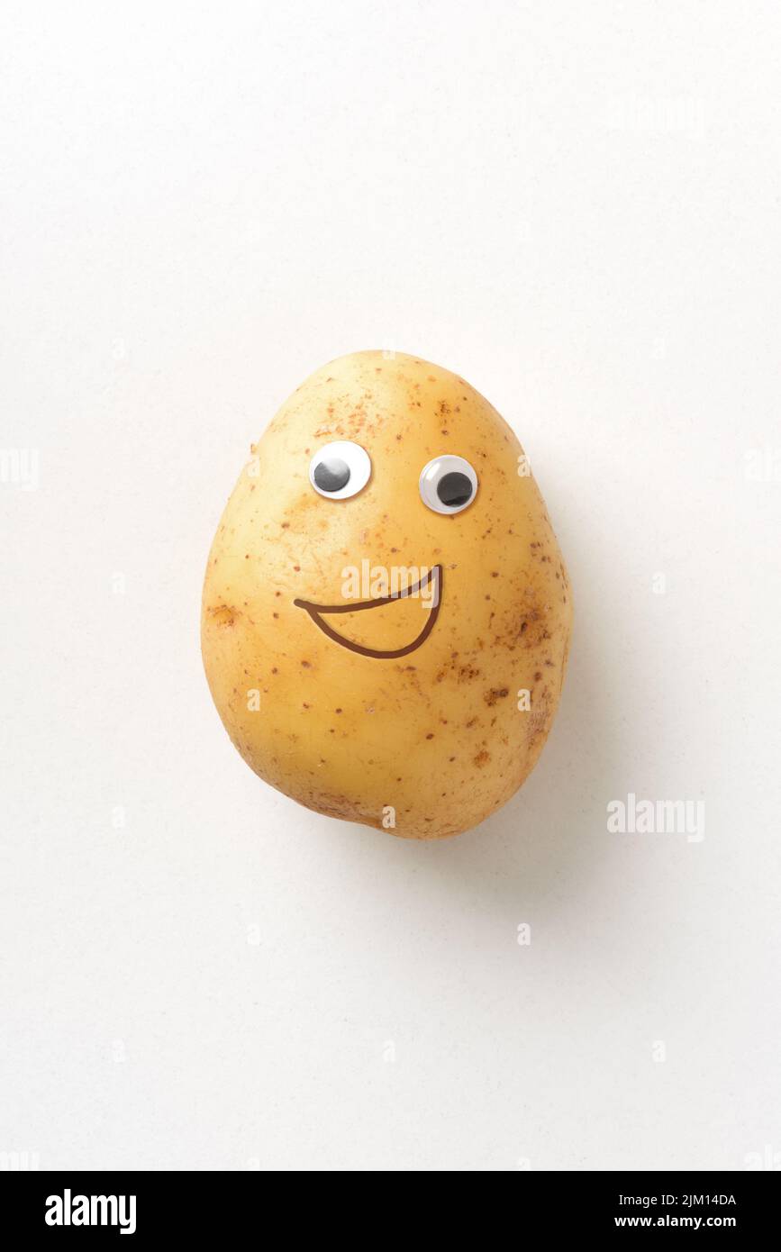 Fresh happy potato with eyes and mouth on white isolated background. Fruits and vegetables child healthy eating concept Stock Photo