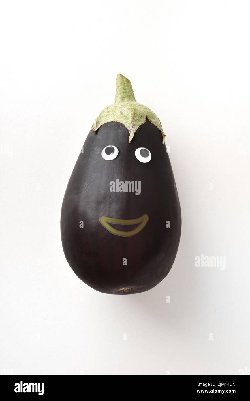 Fresh eggplant with face on white isolated background. Fruits and vegetables child healthy eating concept Stock Photo