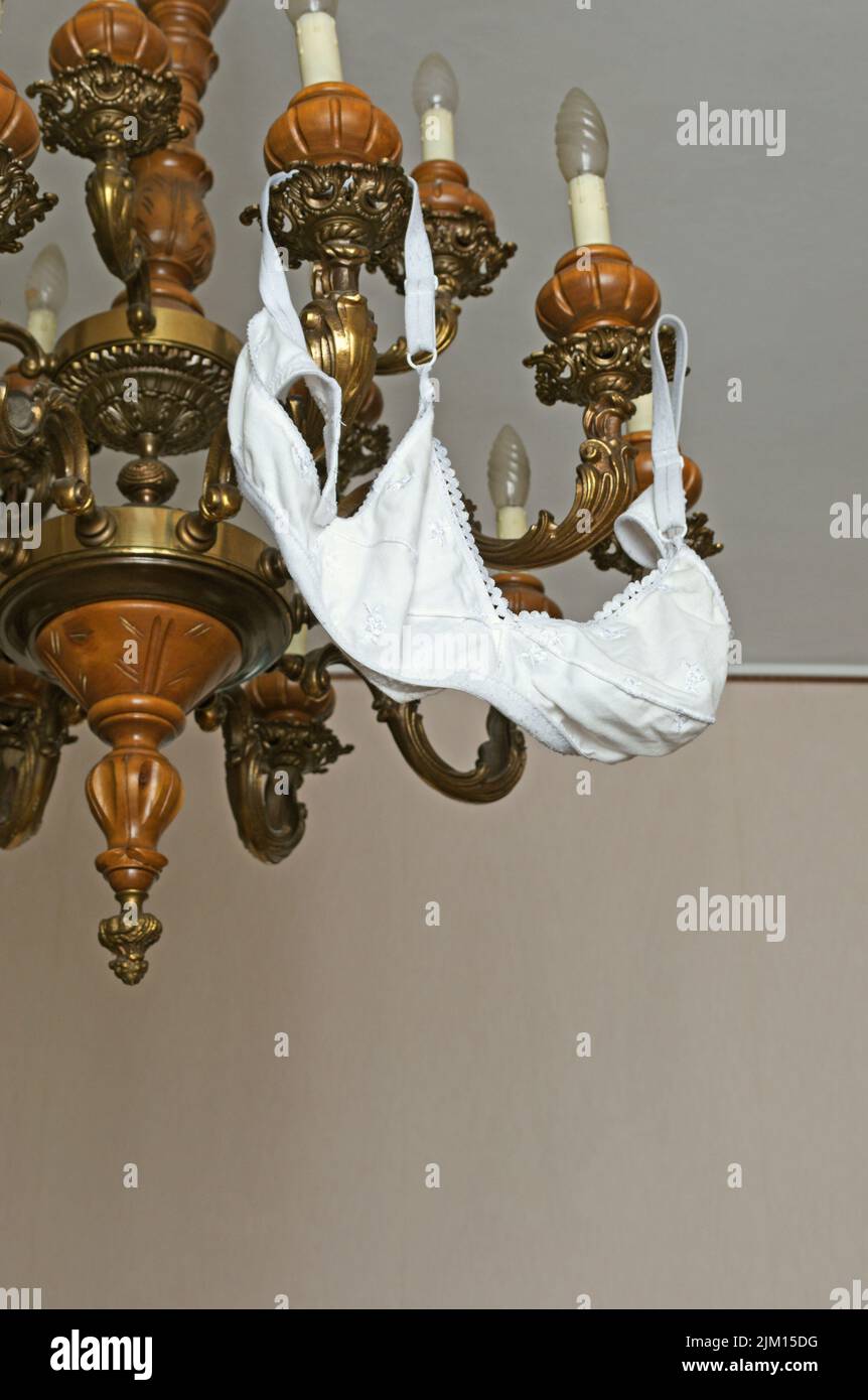 bra on chandelier after a party Stock Photo