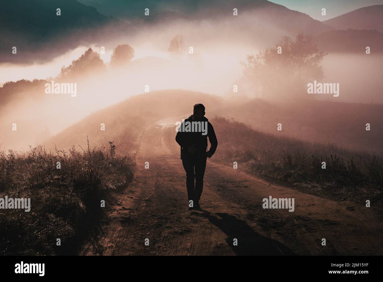man walking in a foggy autumn landscape Stock Photo