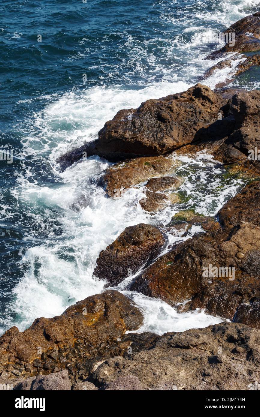 rocks in the sea. waves crashing the shore. water and stone texture. summer nature background Stock Photo