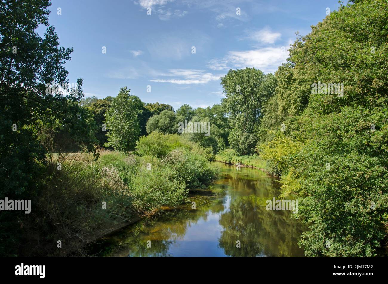 View along the tranquil stream of the river Ems in a lush and green landscape near Münster, Germany, on a summer day Stock Photo