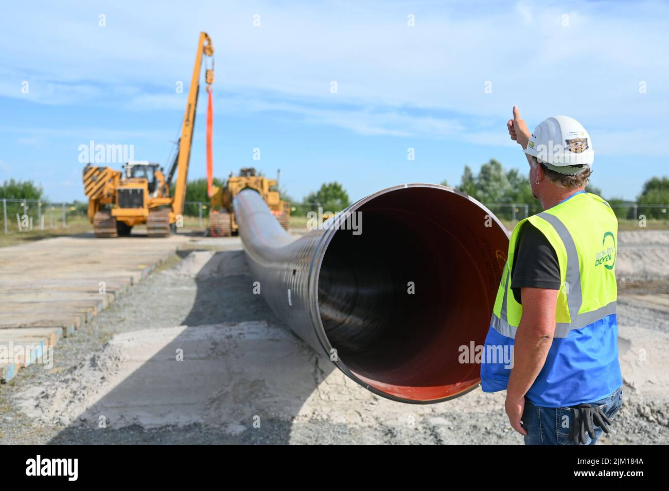 Friedeburg, Germany. 04th Aug, 2022. A construction machine lays pipes