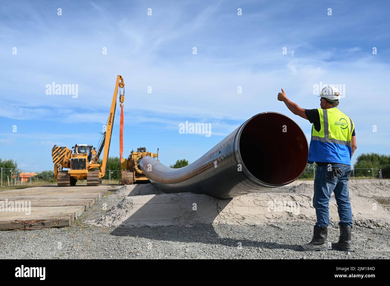 Friedeburg, Germany. 04th Aug, 2022. A construction machine lays pipes