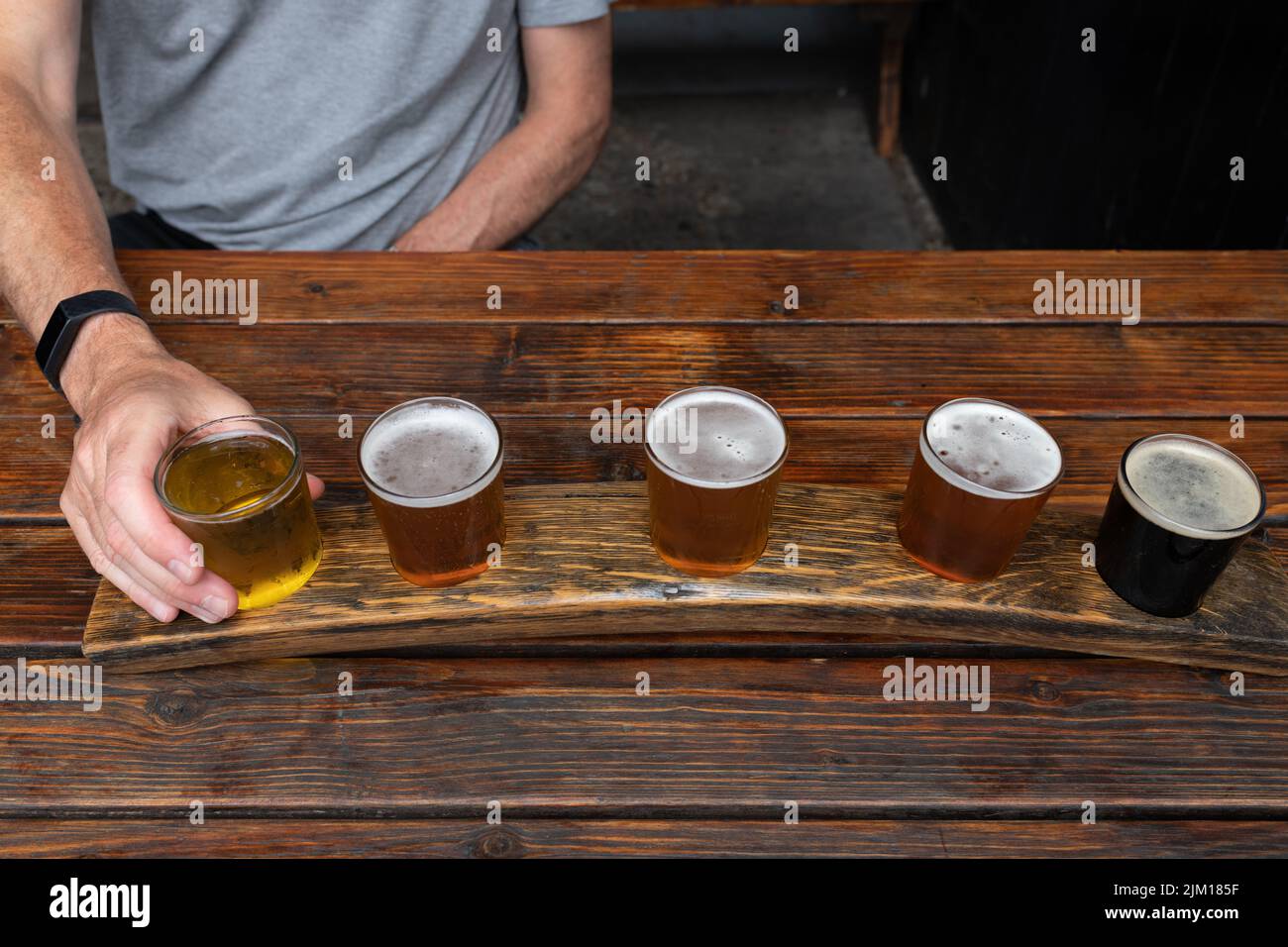 Beer flight or taster tray with cider, lager, pale ale, IPA and stout brewed by Canterbury Brewers - The Foundry Brew Pub, Canterbury, Kent, England Stock Photo