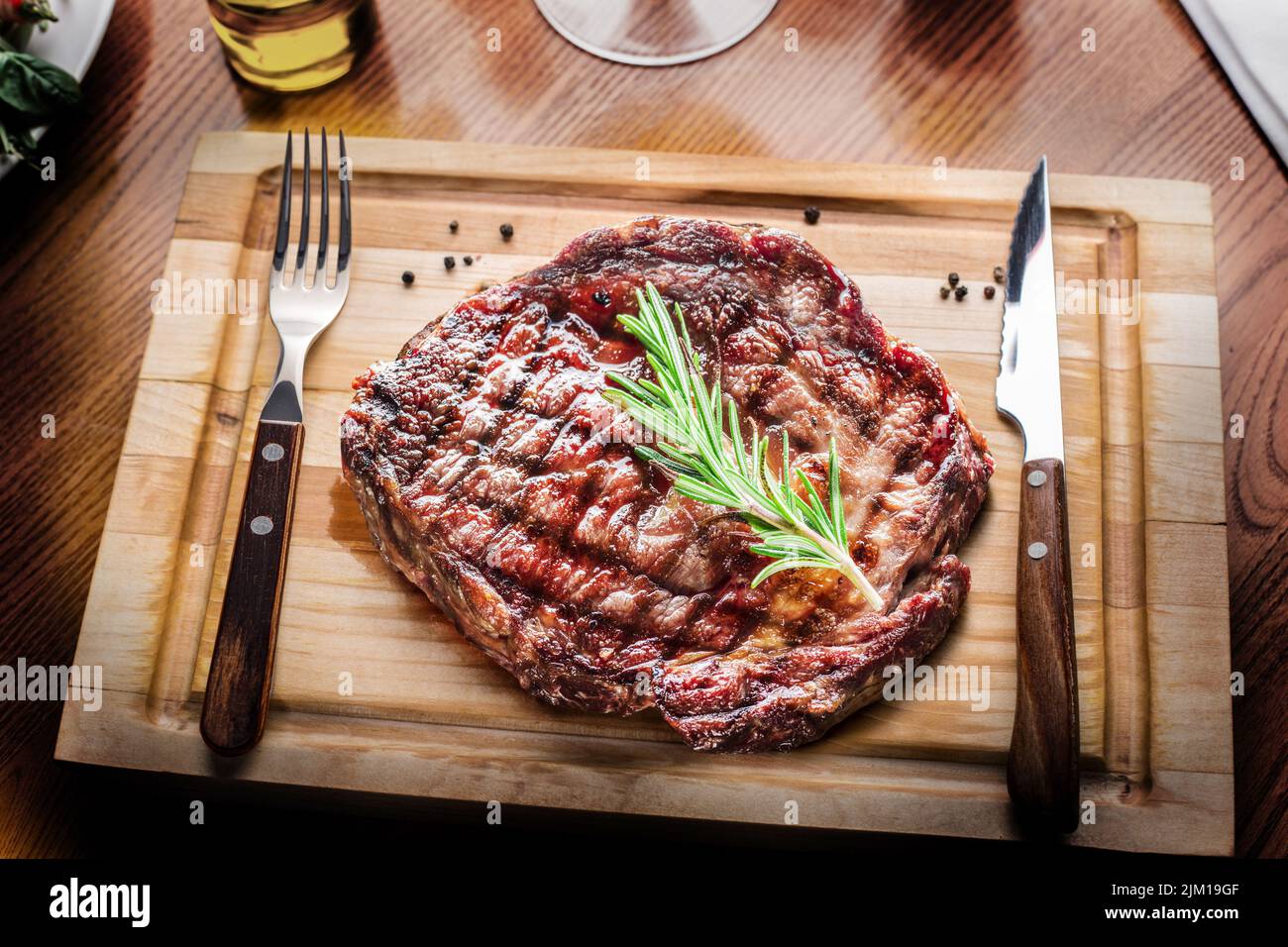 Grilled medium rare steak Mignon on wooden board ready to be eaten. Stock Photo