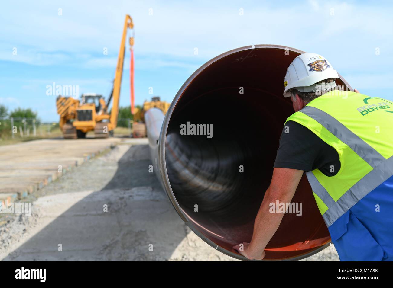 Friedeburg, Germany. 04th Aug, 2022. A construction machine lays pipes