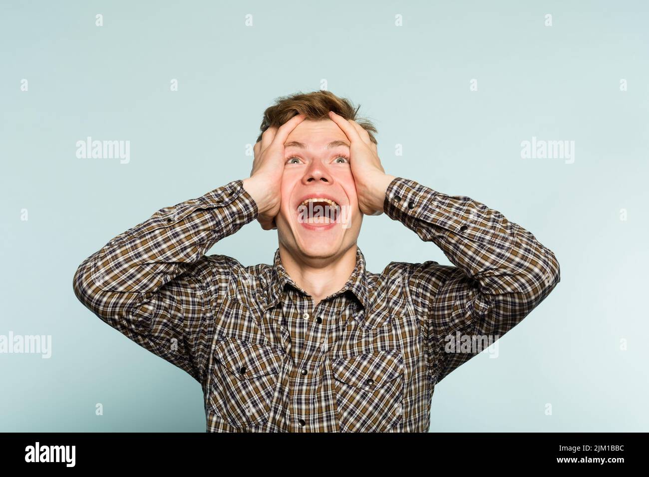 overjoyed happy excited man clutching head emotion Stock Photo