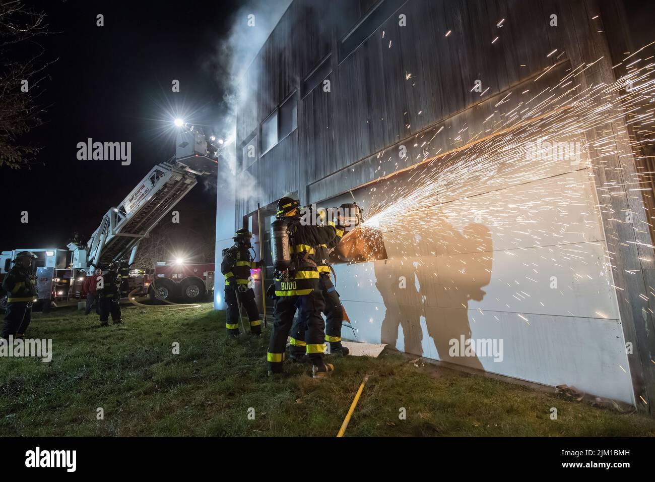 East Hampton fireffighters use a saw to cut open a garage door as members of the East Hampton Fire Department were joined by members for the Sag Harbo Stock Photo