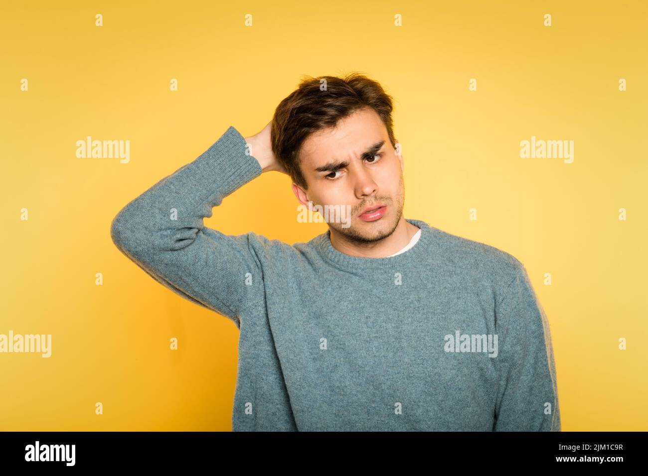 doubtful uncertain hesitant man scratch expression Stock Photo