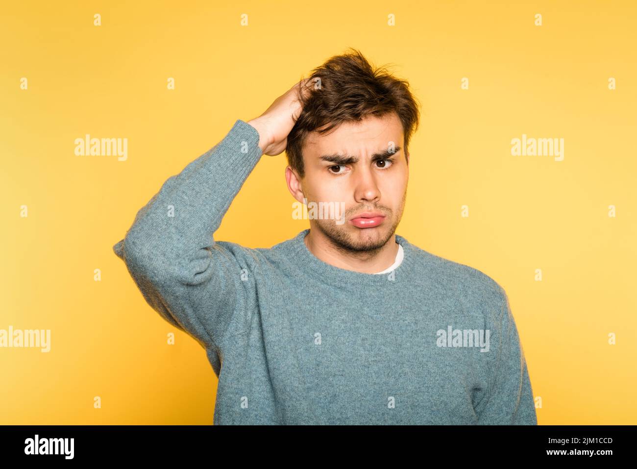 perplexed confused man scratch head look owlishly Stock Photo