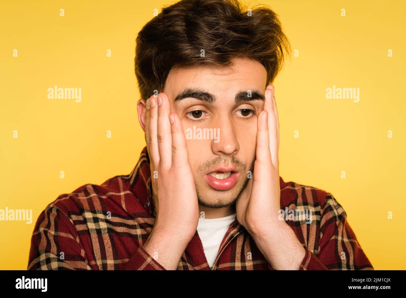 dumbfounded man clutching head panicking emotion Stock Photo