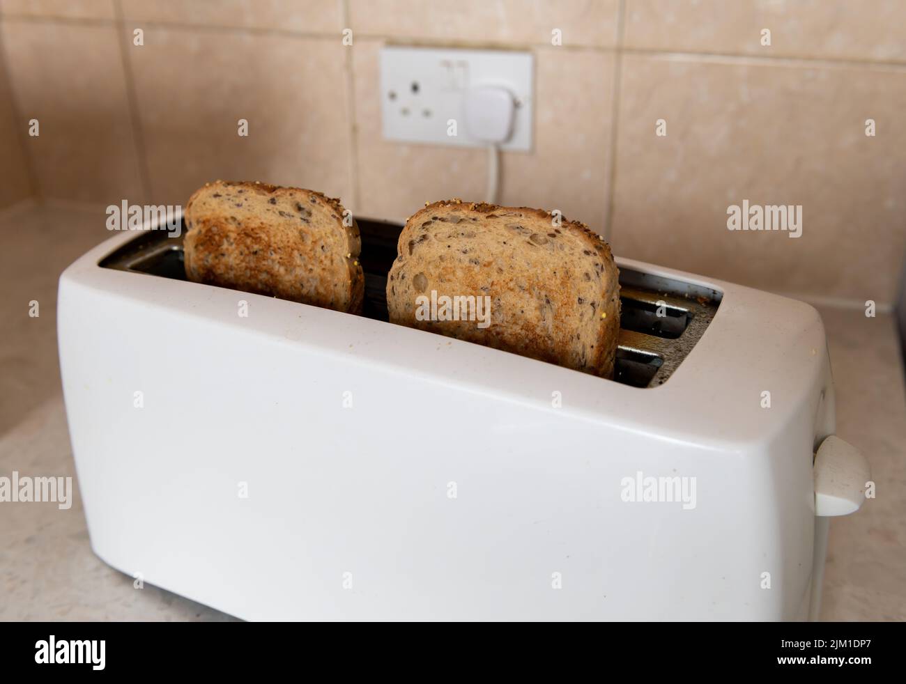 A electric toaster with two pieces of toasted sliced bread. Energy use,cost of living concept. Stock Photo