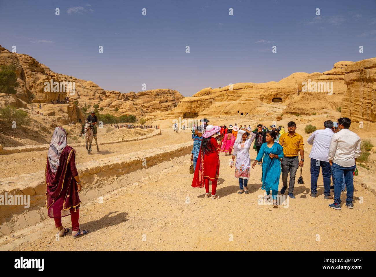 Crowds of people walking down the entrance road to Al-Siq and Petra in Wadi Musa Jordan Stock Photo