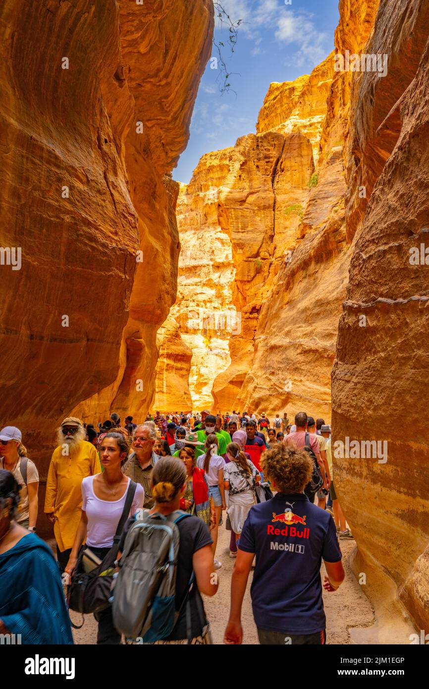 Crowds walking down Al-Siq canyon. The entrance to Petra Jordan. Stock Photo