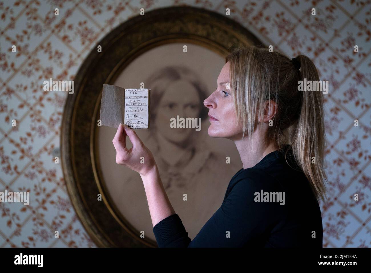 Curator Sarah Laycock with the last Charlotte Bronte miniature manuscript book known to be in private hands, as the book goes on display following its return to the Bronte Parsonage Museum in Haworth, Keighley, West Yorkshire, once the home of the Bronte family. Picture date: Thursday August 4, 2022. Stock Photo
