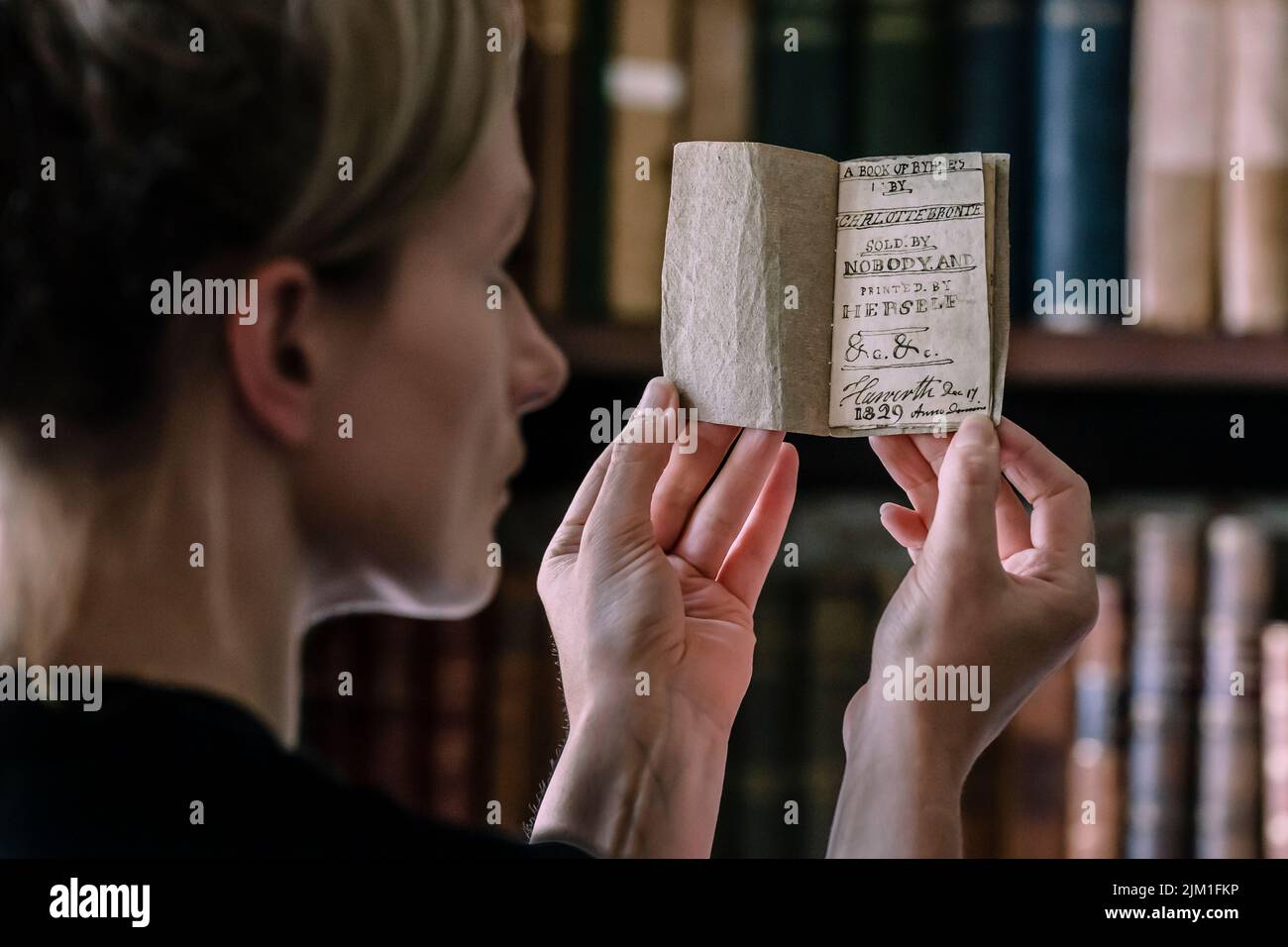 Curator Sarah Laycock with the last Charlotte Bronte miniature manuscript book known to be in private hands, as the book goes on display following its return to the Bronte Parsonage Museum in Haworth, Keighley, West Yorkshire, once the home of the Bronte family. Picture date: Thursday August 4, 2022. Stock Photo