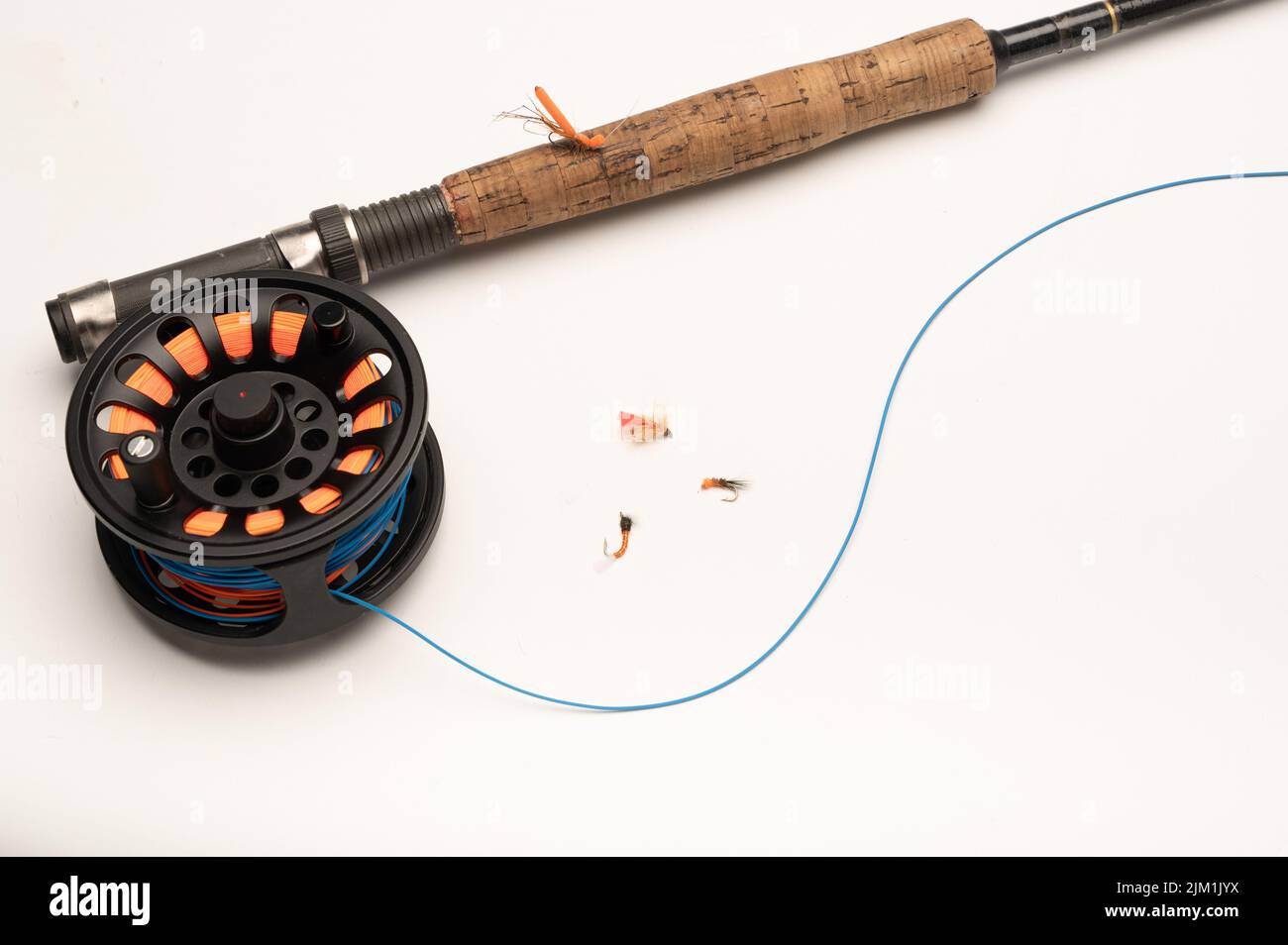 Fly fishing reel, rod, and flies on a white background with copy space Stock Photo