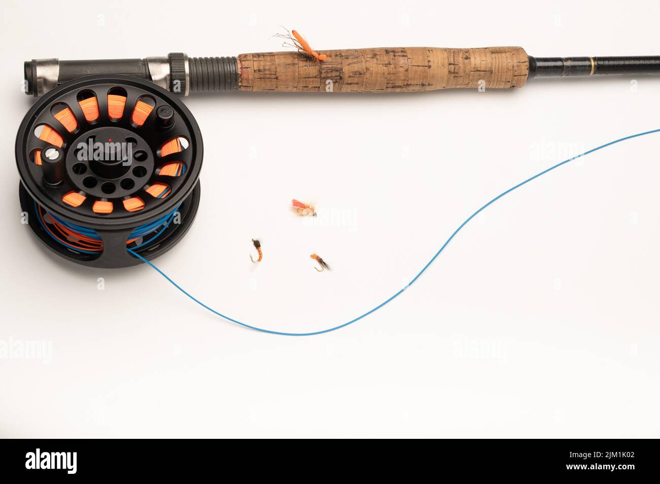 Fly fishing reel, rod, and flies on a white background with copy space Stock Photo
