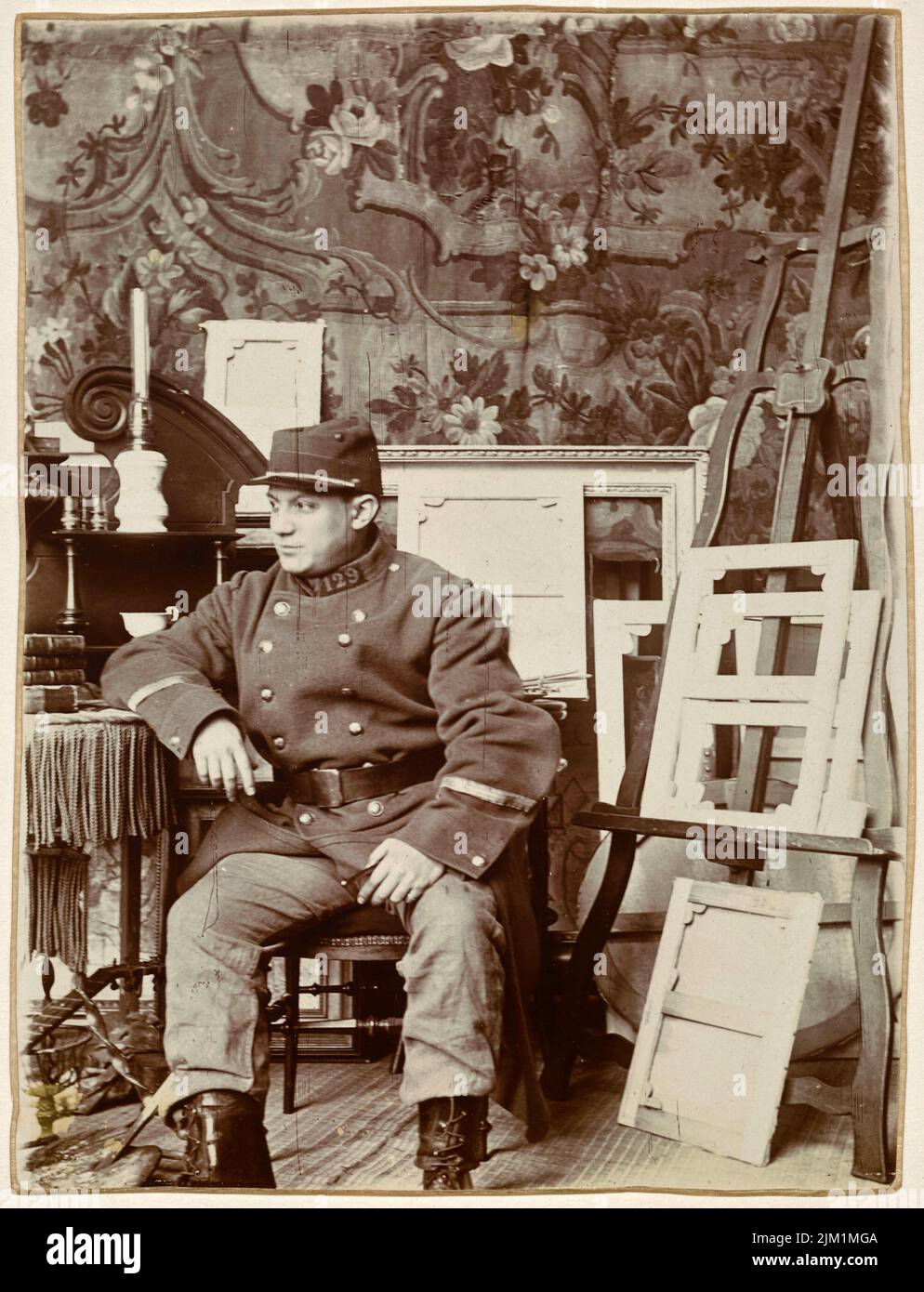 Pablo Picasso in his studio wearing Georges Braque's military uniform. Museum: PRIVATE COLLECTION. Stock Photo