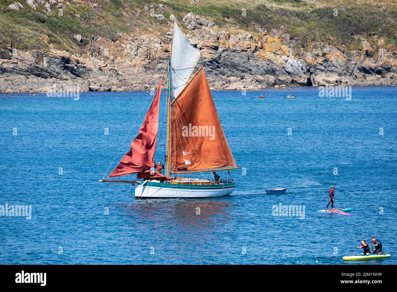 A yacht sails in Coverack, Cornwall,UK Stock Photo