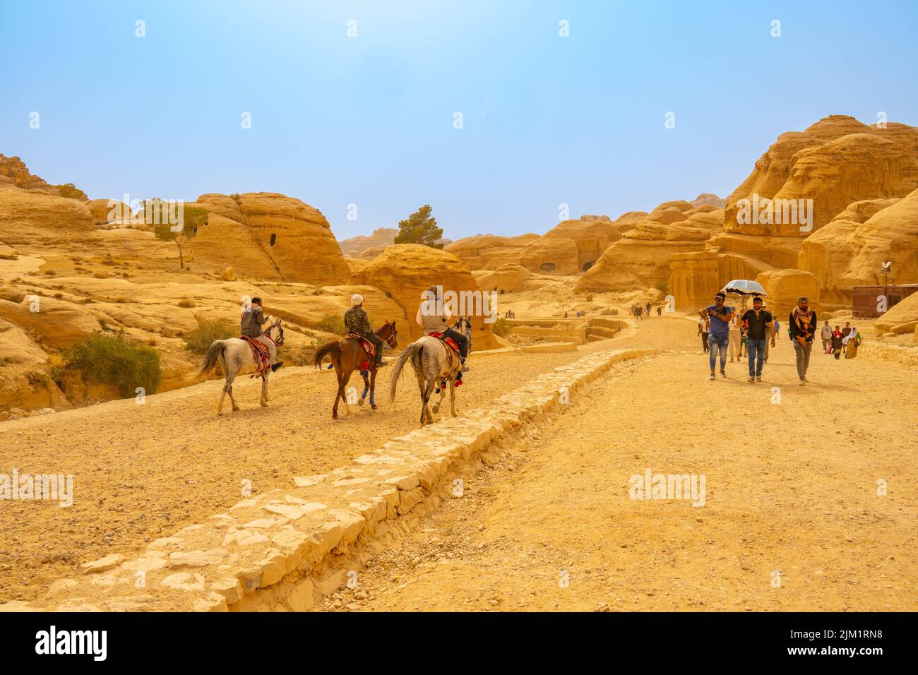 Crowds of people walking up the entrance road from Al-Siq and Petra in Wadi Musa Jordan Stock Photo
