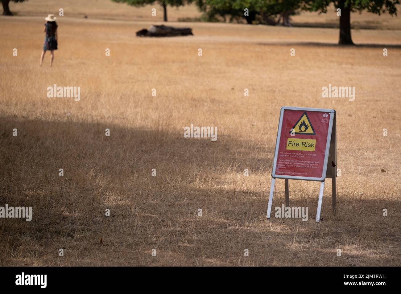 Richmond Park, London, UK. 4 August 2022. Fire risk sign in Richmond Park. Drought conditions continue around London and the South East of England. Grassland in Richmond Park is straw-like after weeks without rain and having endured temperatures of 40 degrees. Hot weather with no rain forecast is currently due to continue in the region till mid August. Credit: Malcolm Park/Alamy Live News Stock Photo