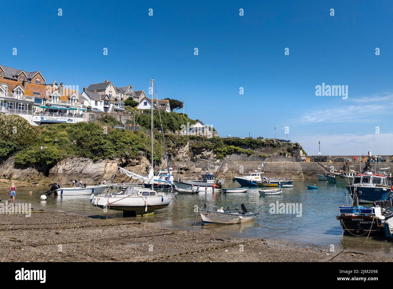 Fishing boats and Sailboats moored in the picturesque Newquay Harbour in Cornwall in England in the UK. Stock Photo